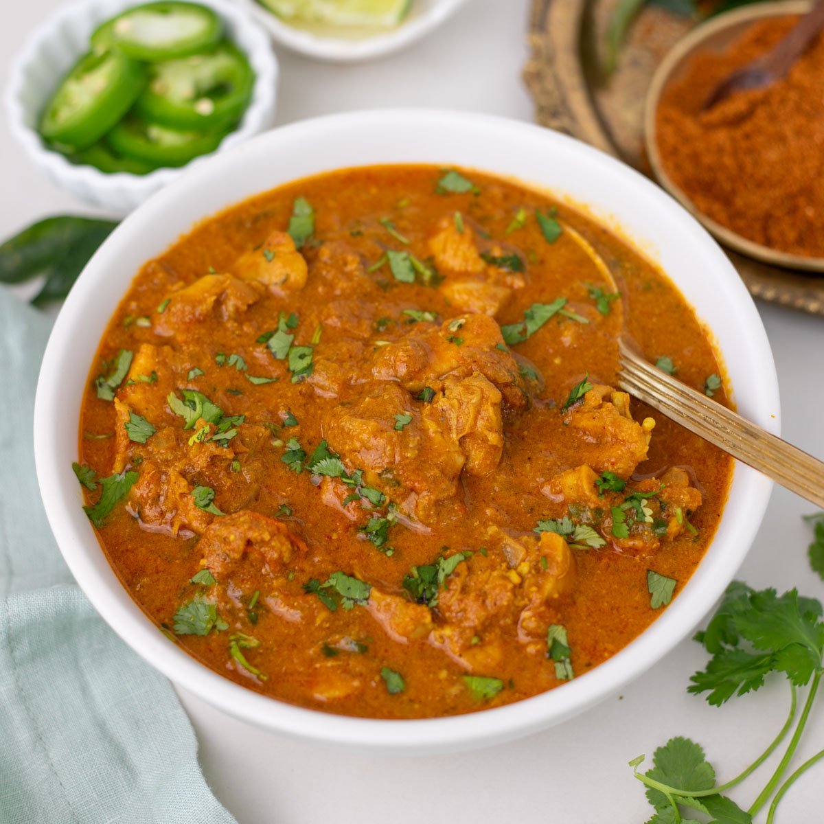 Chicken Chettinad in a white bowl garnished with cilantro