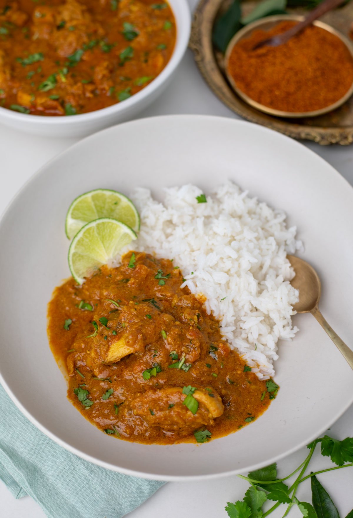 Chicken chettinad with rice served on a white plate