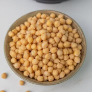 A bowl of cooked chickpeas placed in front of the instant pot.