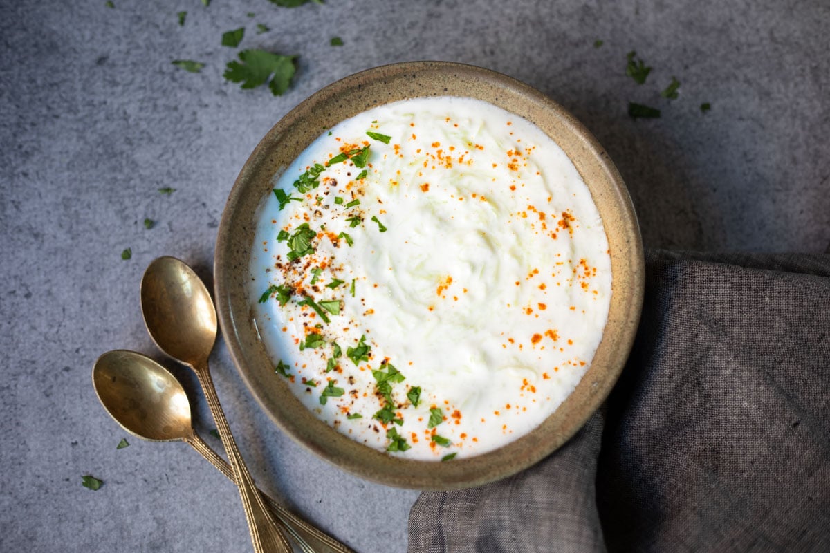 Ready to serve lauki raita garnished with cilantro and red chili powder