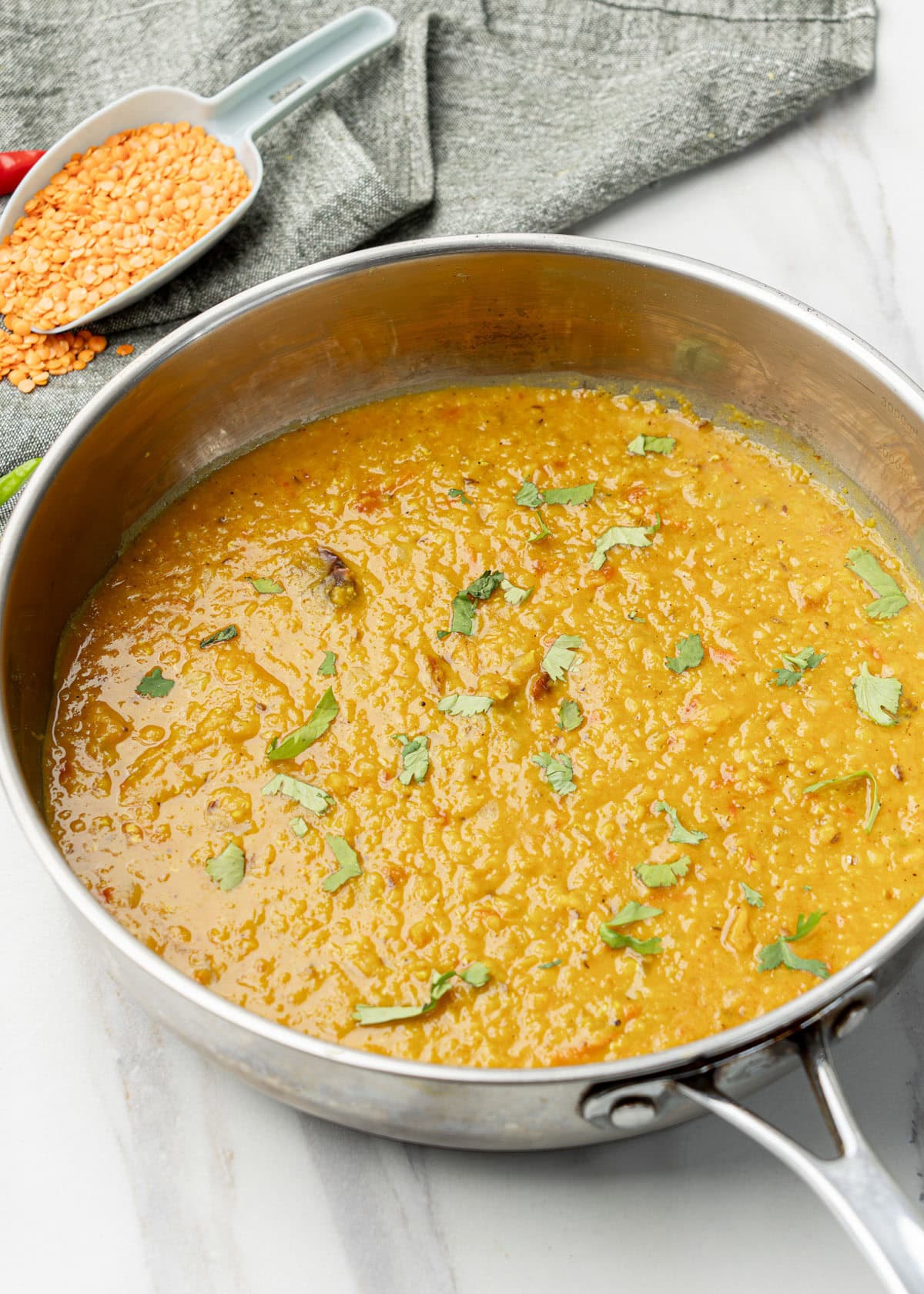 masoor dal in a pan with fresh masoor dal at the back