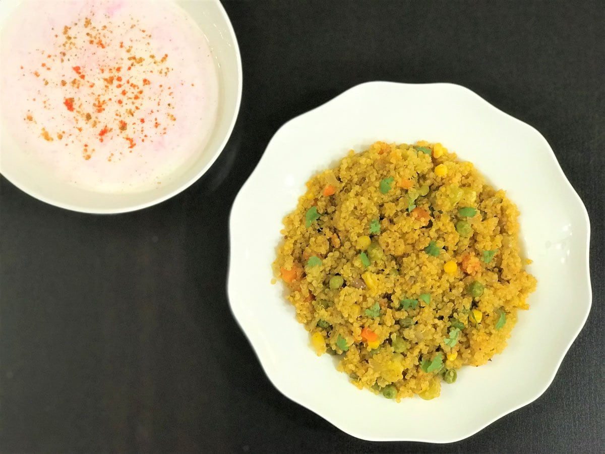 A plate of quinoa pulao with raita on side