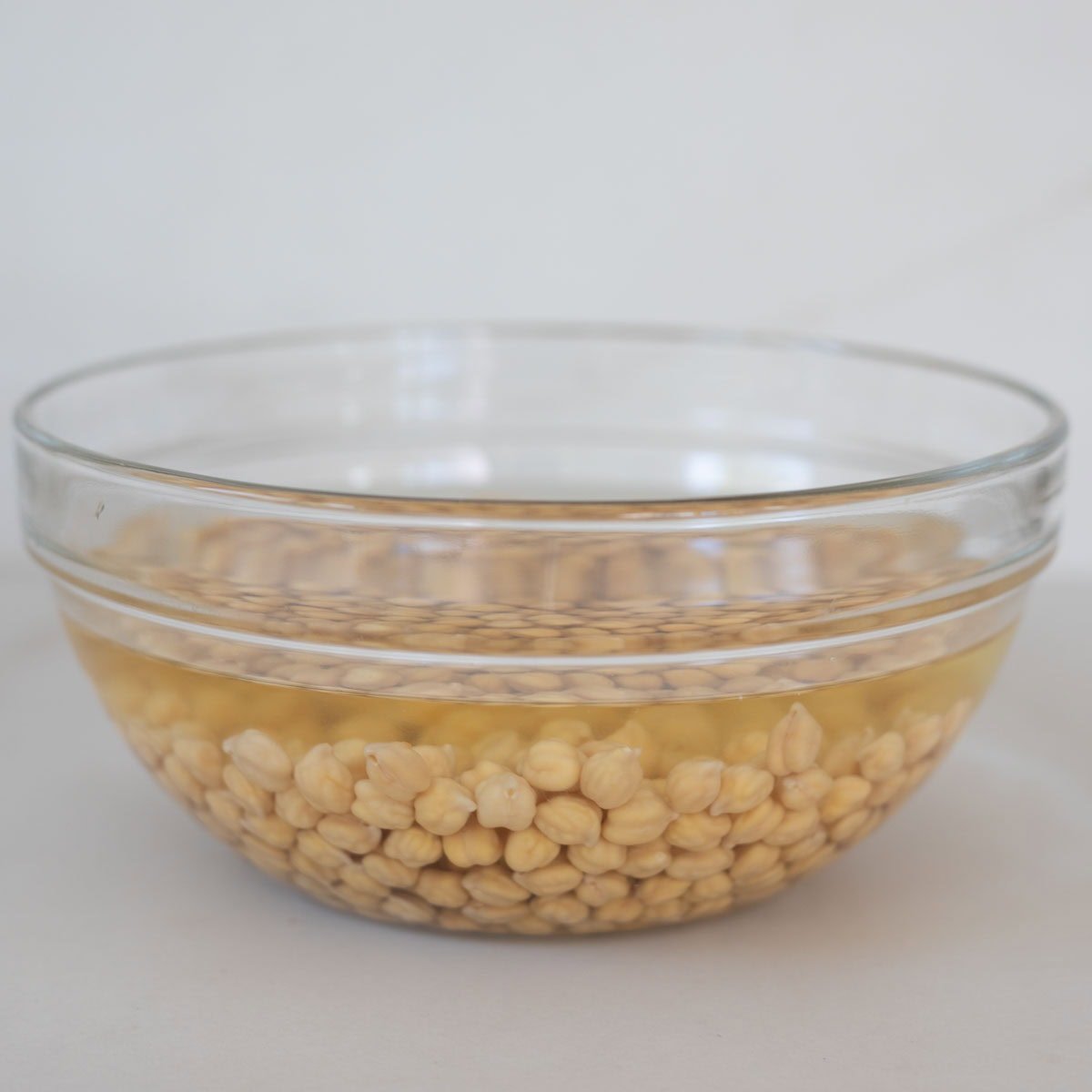 Soaked chickpeas in a glass bowl.