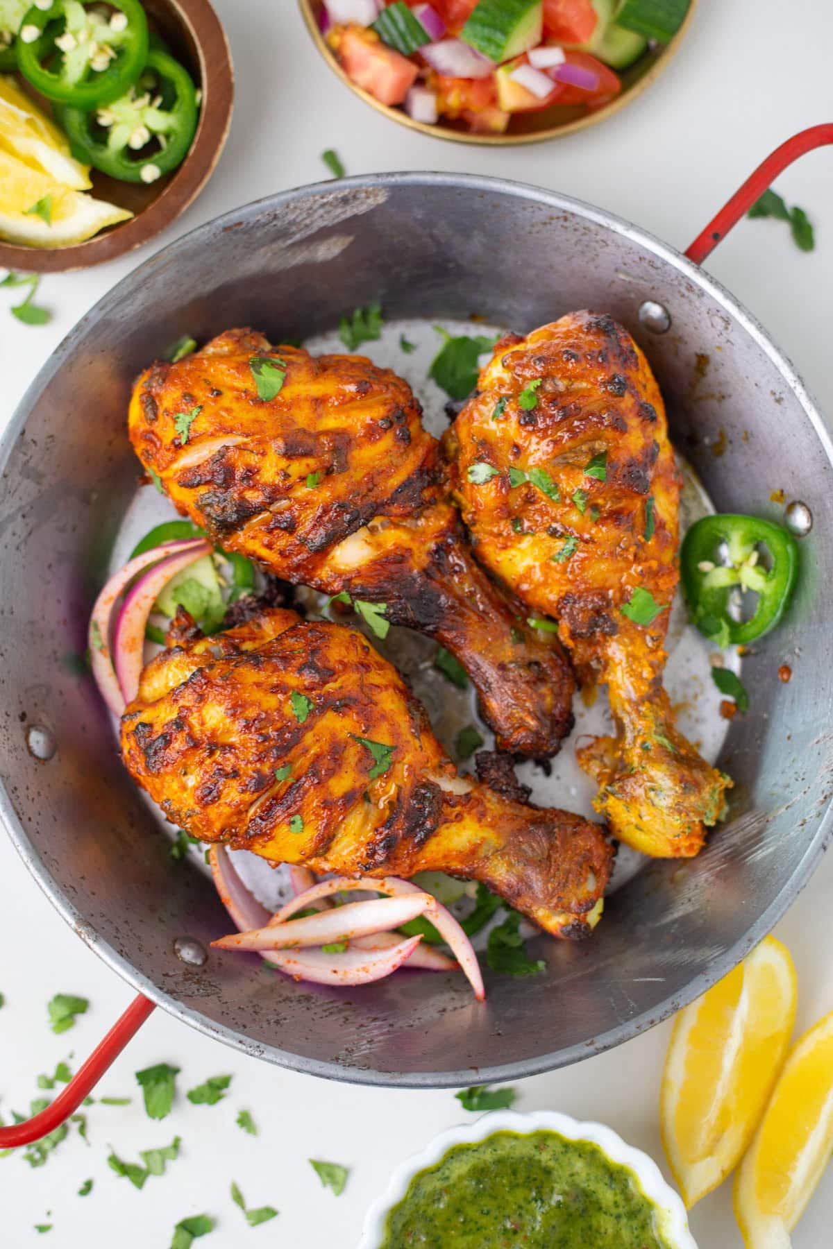 closeup shot of tandori chicken leg in a small pot