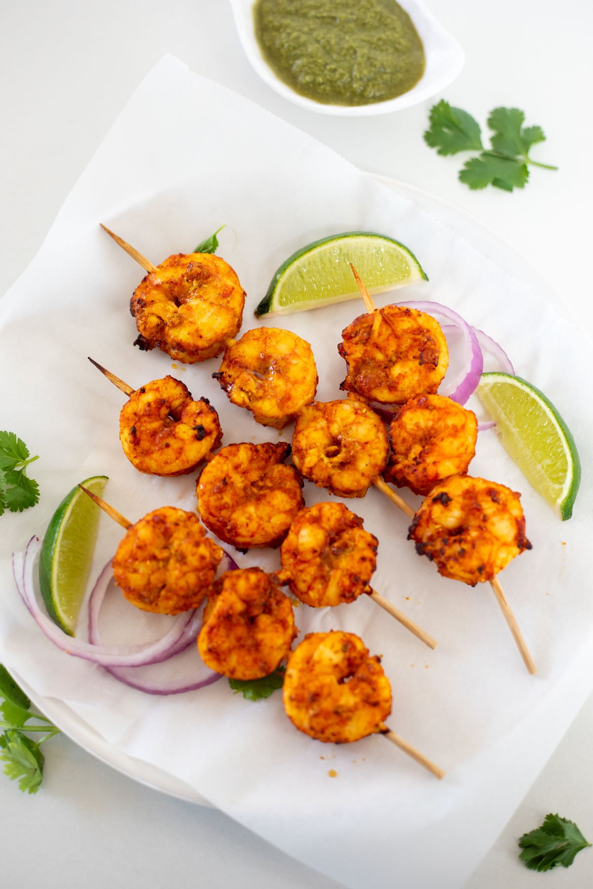 Tandoori shrimp in skewers with lime and onion on side