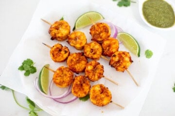 air fried tandoori shrimp in skewers with lime and onion slice