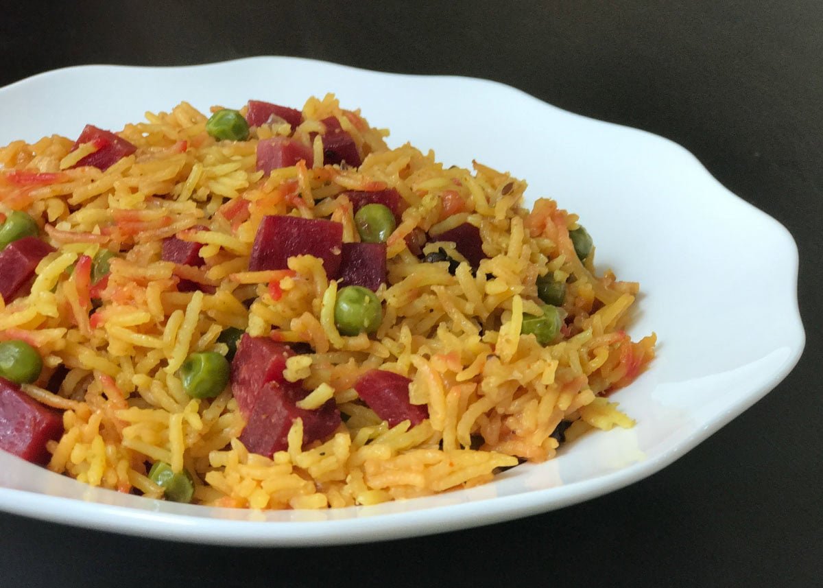 Closeup shot of beet pulao on a white plate