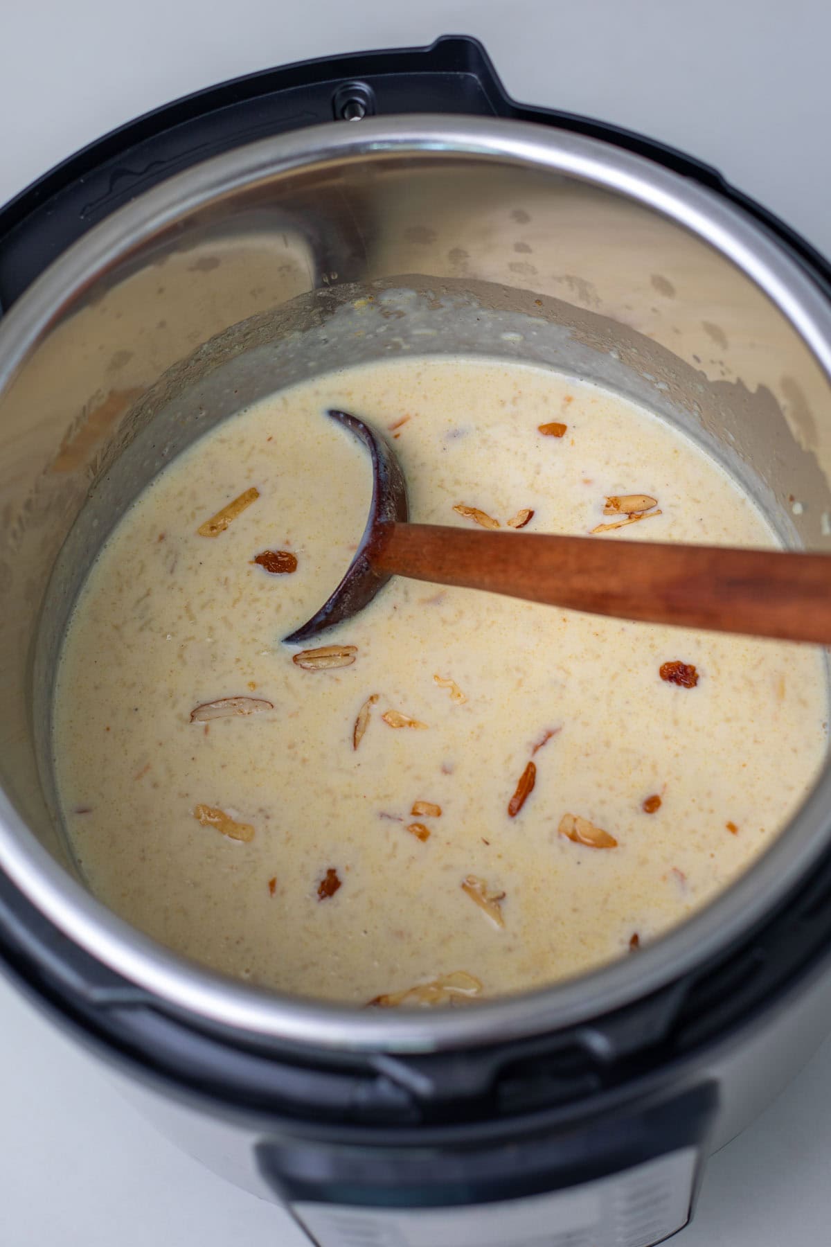 rice kheer in instant pot with a wooden ladle