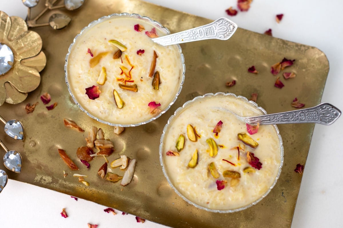 Two bowls of instant pot rice kheer garnished with nuts