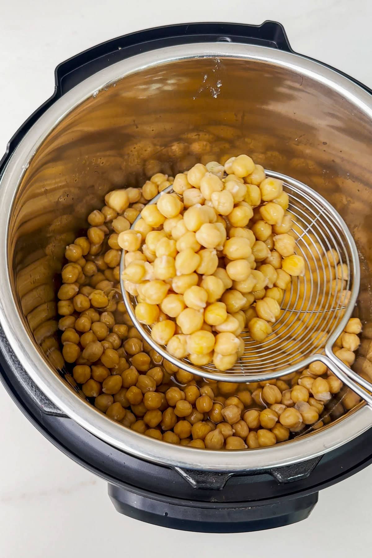 Tender cooked instant pot chickpeas in a ladle