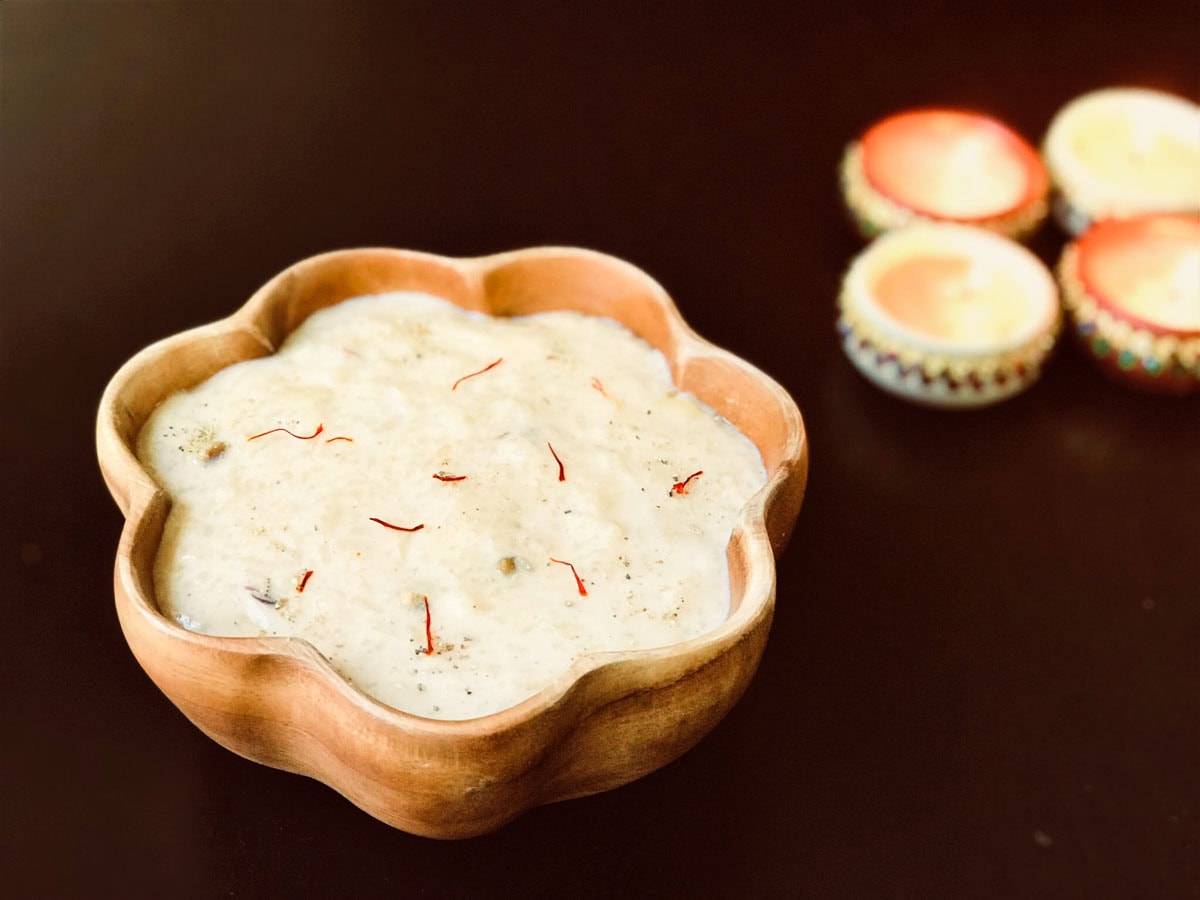 Instant pot rice kheer in a wooden bowl with saffron on top