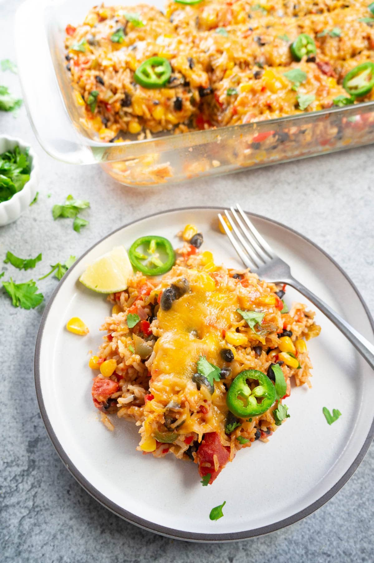 Vegetarian Mexican Casserole with Rice & Beans served on a white plate along with a fork.