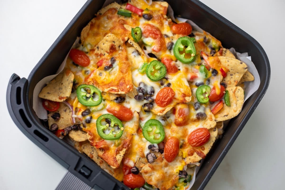 nachos with tomatoes and jalapeno in air fryer basket
