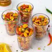 Four cups with peanut chaat on a white plate
