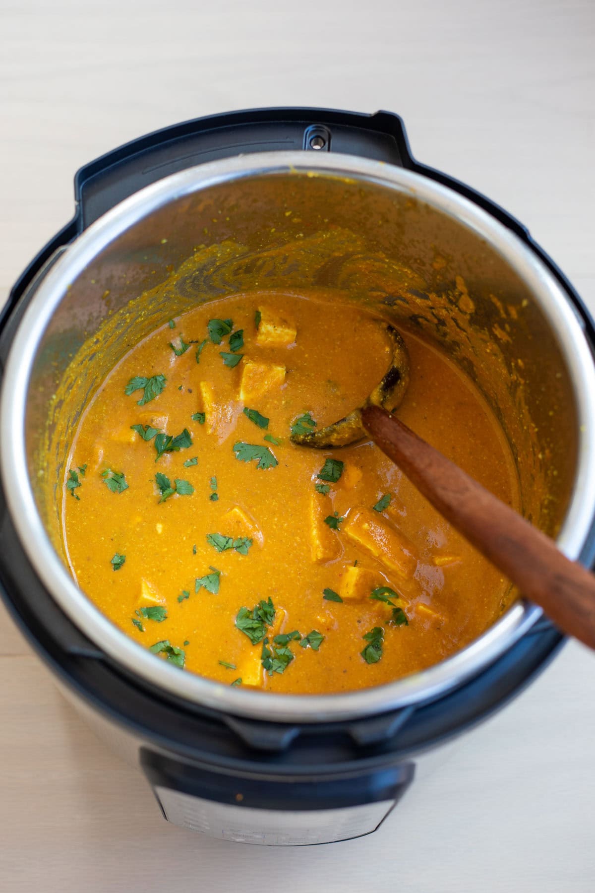paneer butter masala in instant pot with wooden ladle