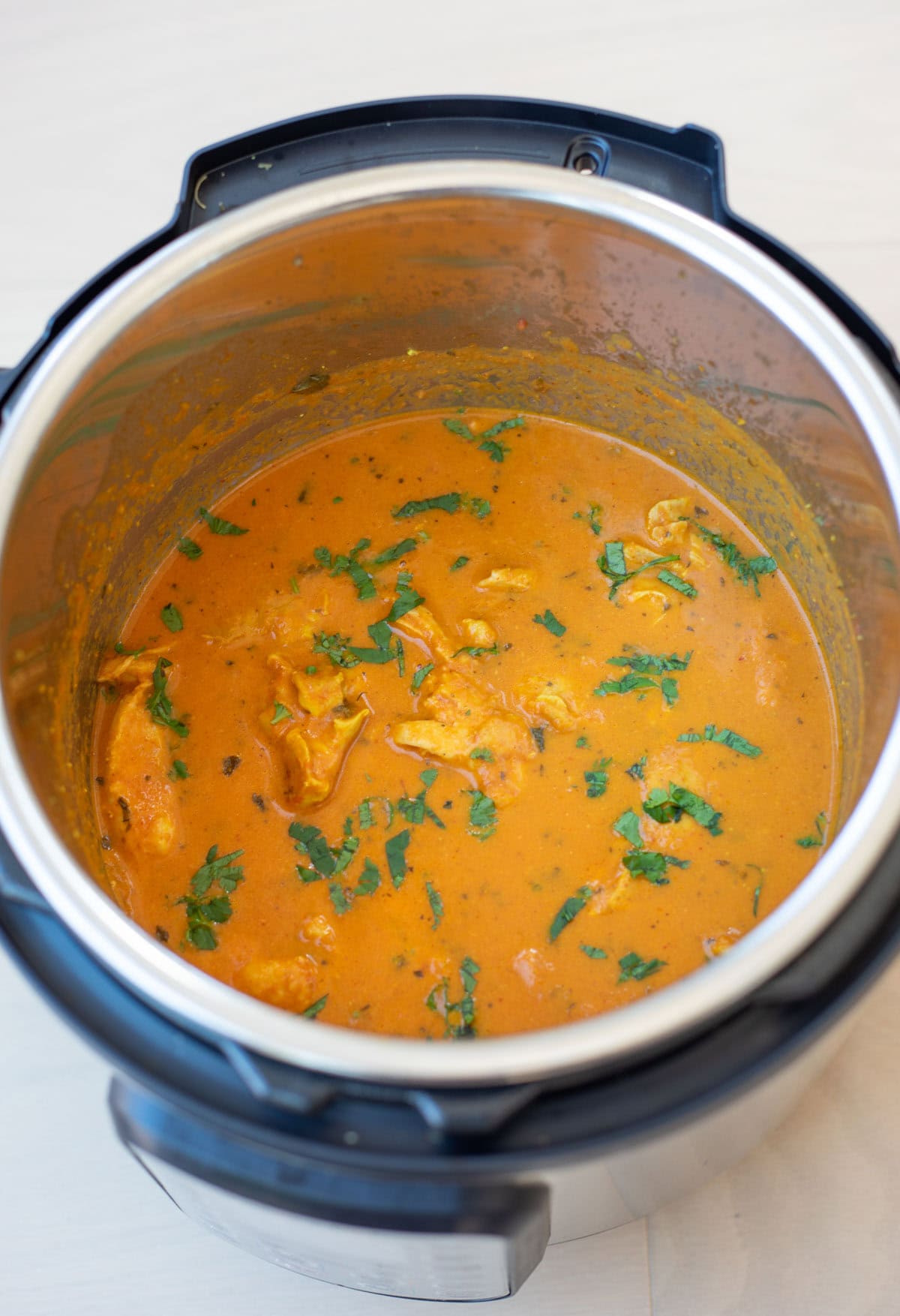 Butter chicken in instant pot garnished with cilantro