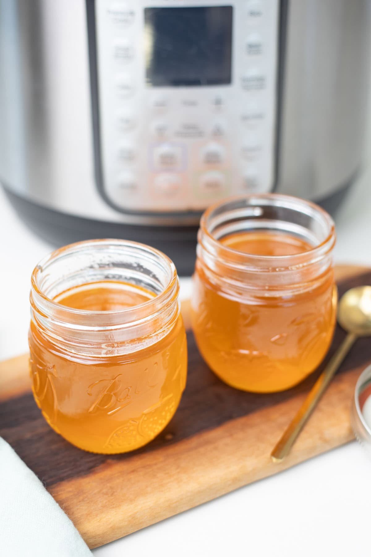 Ghee-filled glass jars placed in front of an Instant Pot.