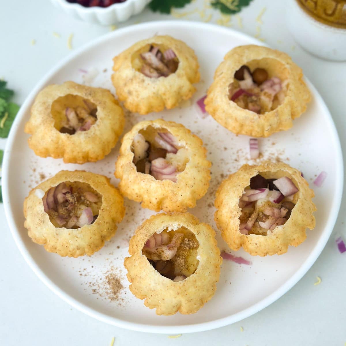 Add onions and spices to puri for dahi puri recipe