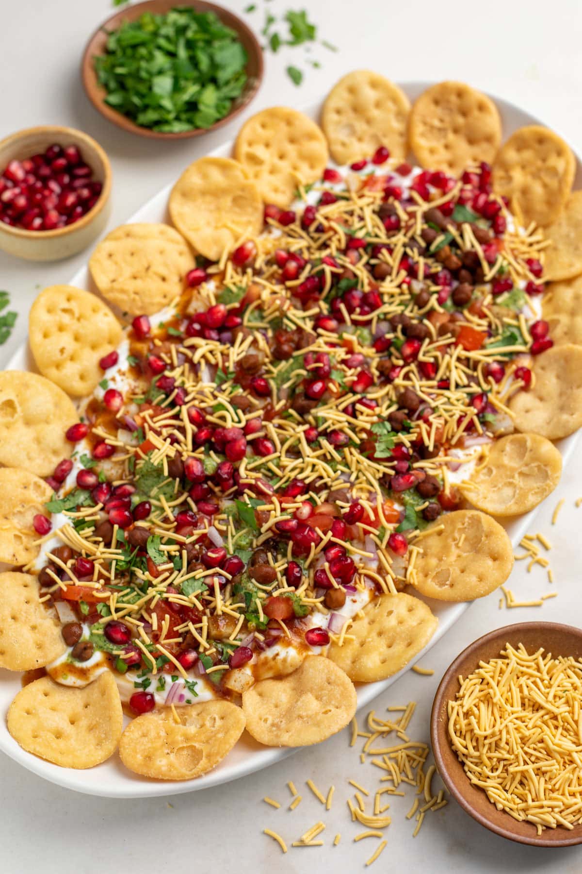 Homemade chaat platter with sev, cilantro and pomegranate seeds on top