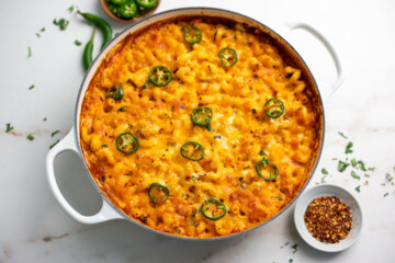 Masala mac and cheese in a pan with chili flakes on side