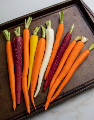 Peeled rainbow carrots in a pan