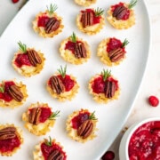 Holiday cranberry chutney brie bites on a white serving plate