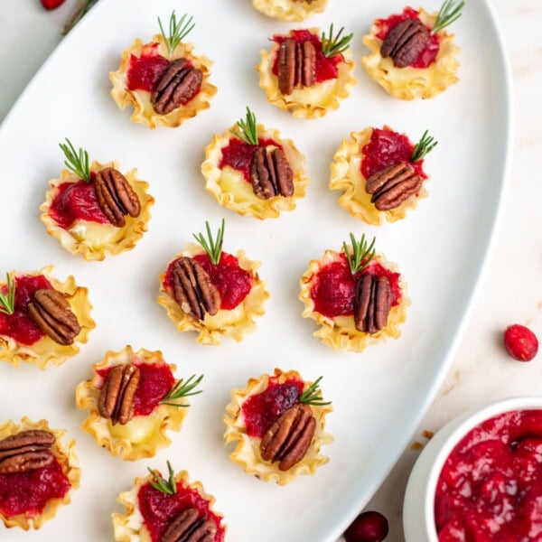 Holiday cranberry chutney brie bites on a white serving plate