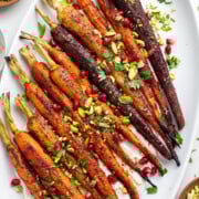 Roasted rainbow carrots topped with cilantro, pistachios and pomegranate seeds