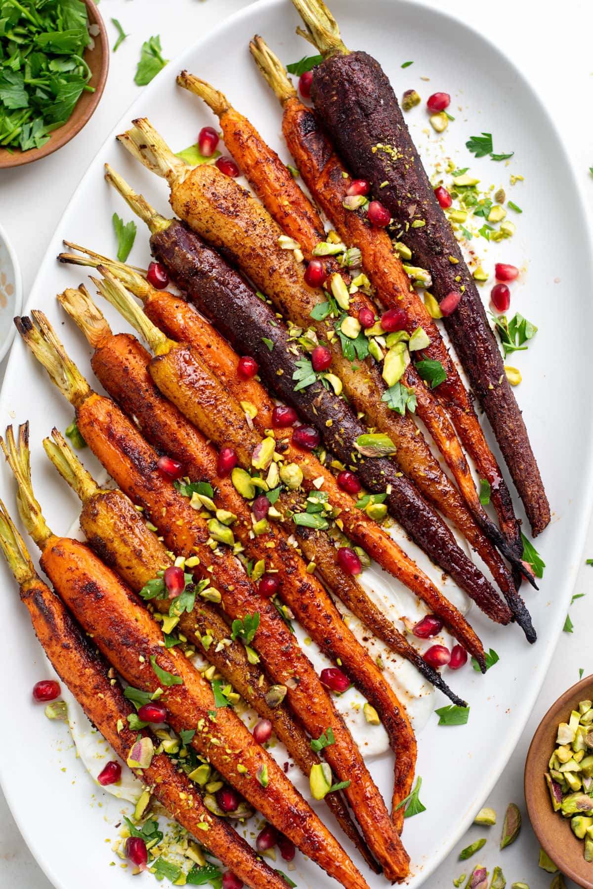 Roasted rainbow carrots topped with cilantro, pistachios and pomegranate seeds
