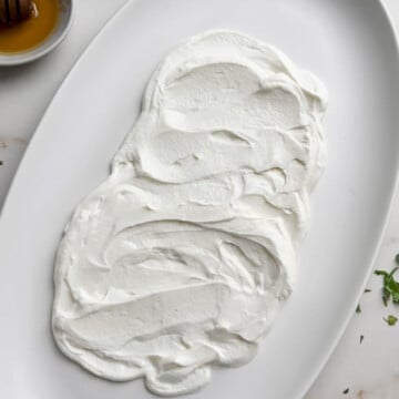 Scatter curd into the platter for roasted rainbow carrot recipe