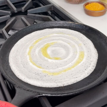 Spread batter on cast iron pan to make dosa