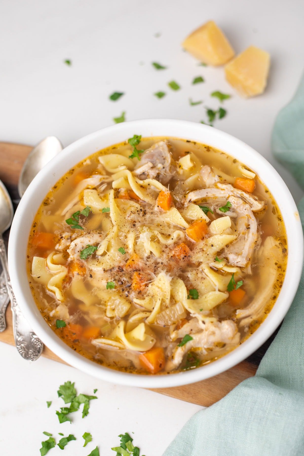 Pressure cooker Chicken noodle soup served in a white bowl garnished with parmesan