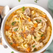 Chicken noodle soup made in instant pot served in a white bowl.