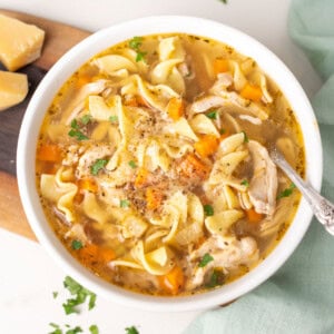 Chicken noodle soup in a white bowl.