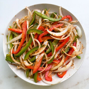 Fajita veggies mixed with spices on a plate