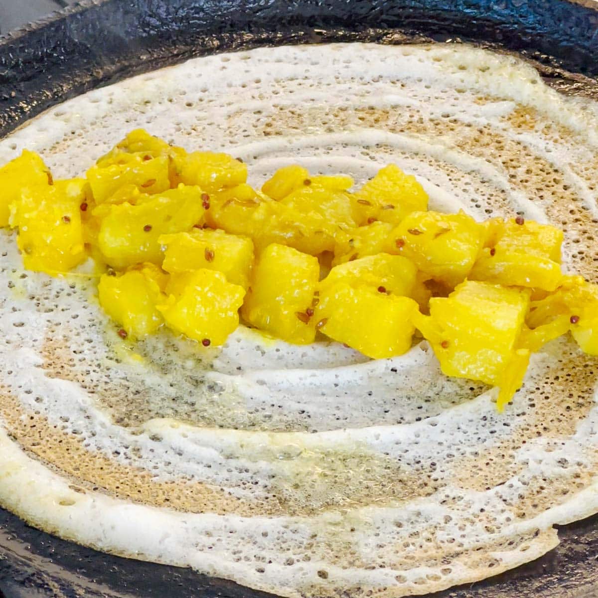 Add potato on the dosa