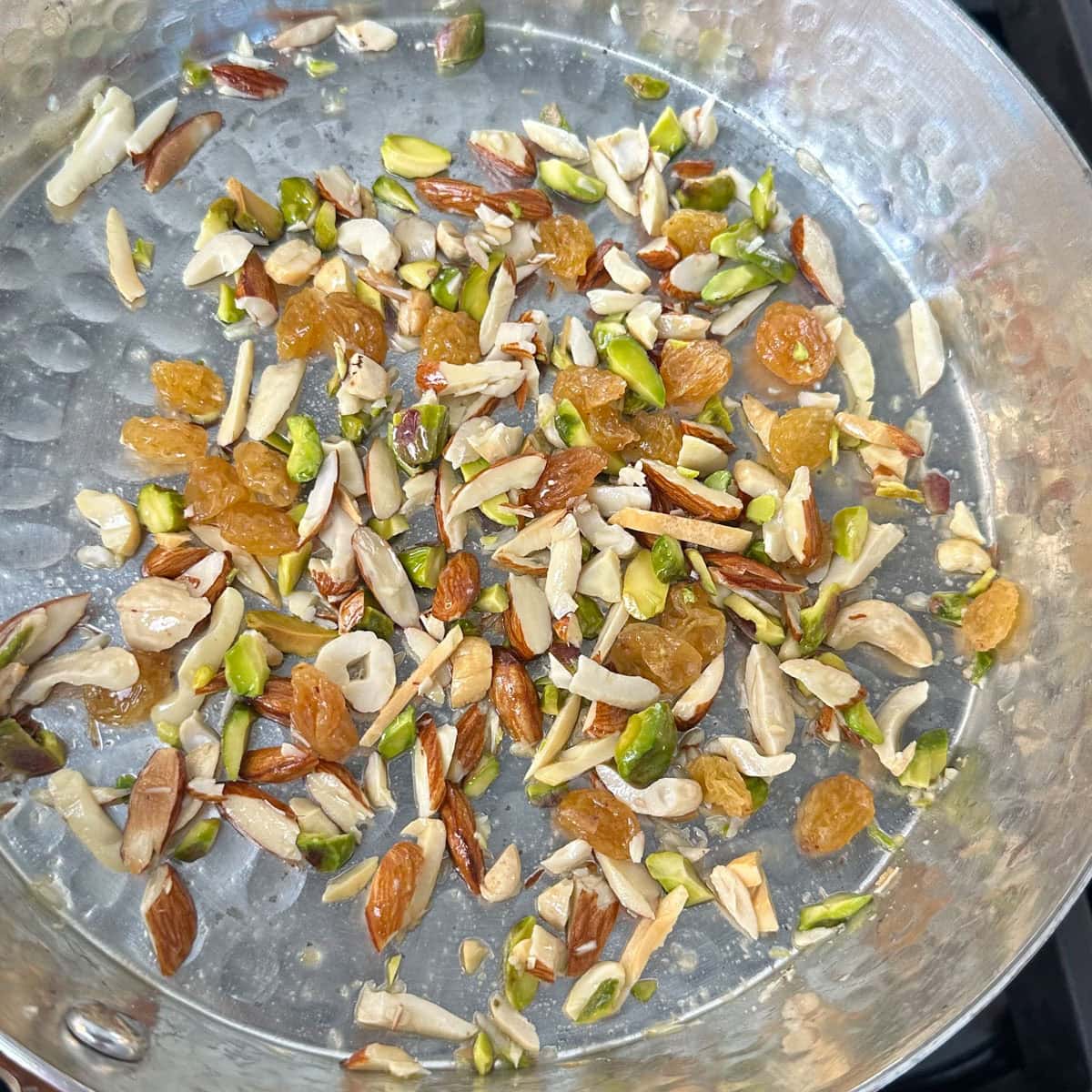 Nuts toasted in ghee in a pan.