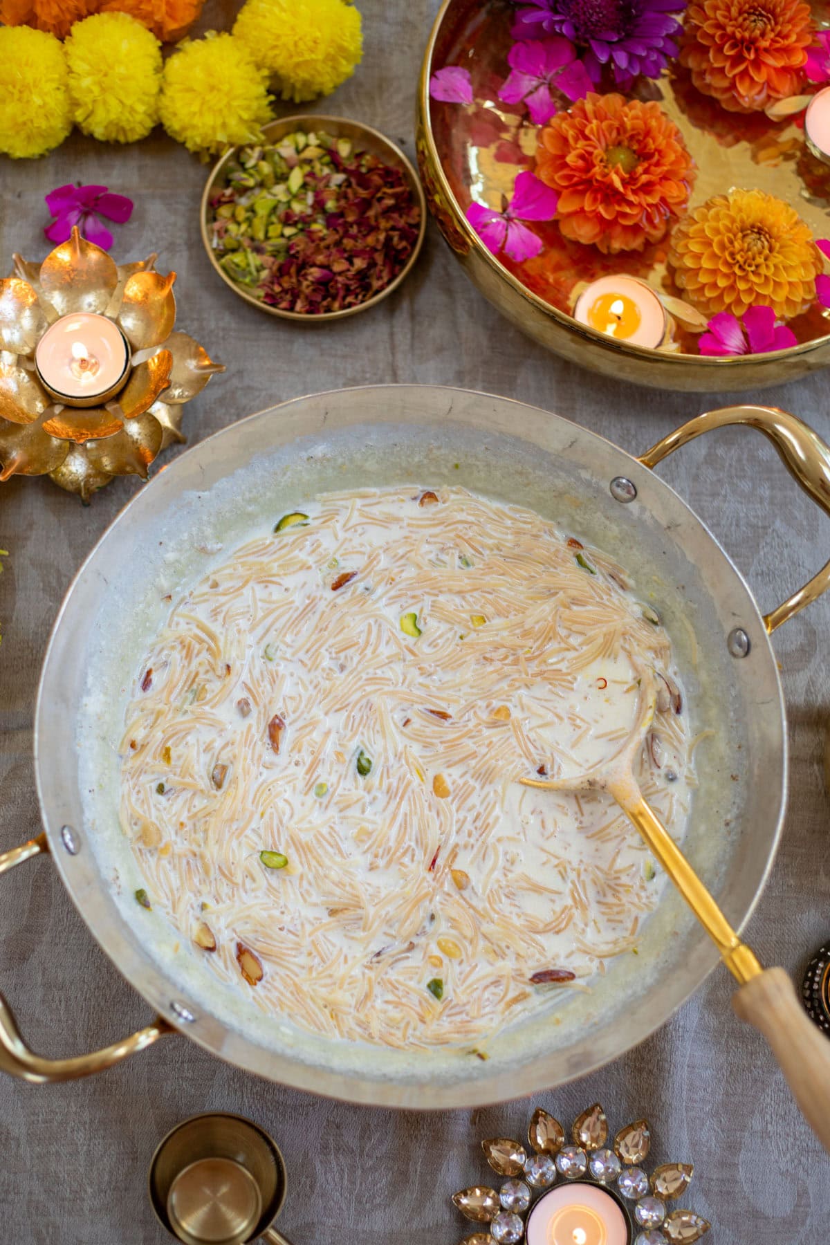Vermicelli Kheer made in a brass pan garnished with nuts.