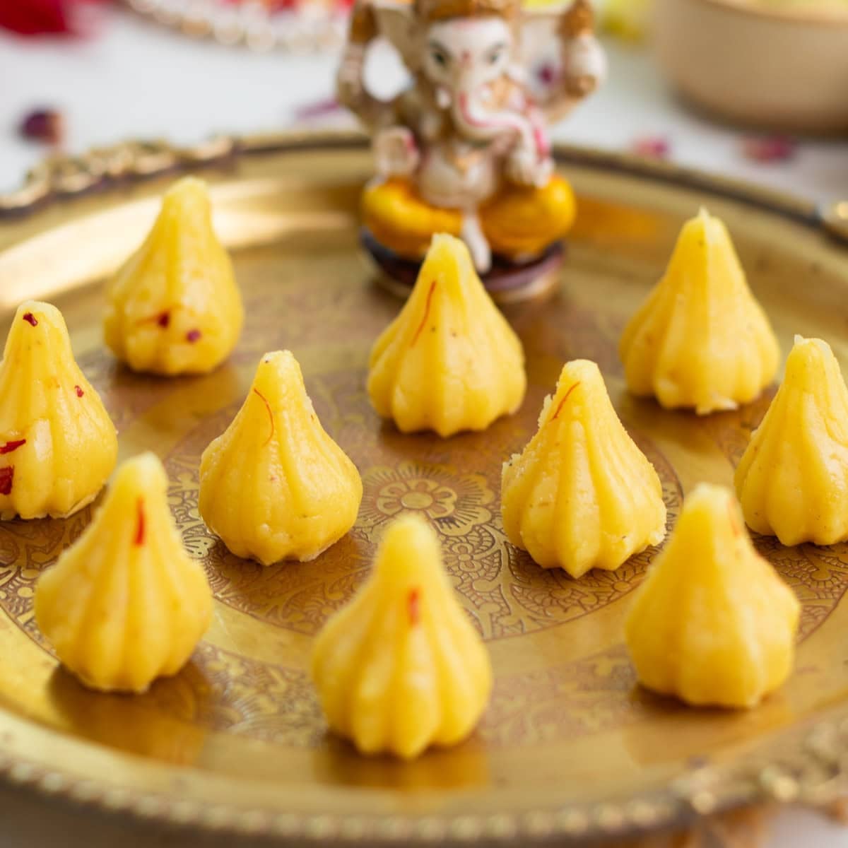 Perfectly shaped malai modak presented to lord ganesha in a brass plate.