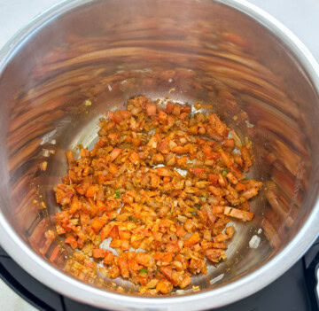 All the aromatics, including onions, tomatoes, and spices, saut&eacute;ed to make pumpkin curry in the Instant Pot
