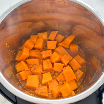 Sliced pumpkin added to instant pot to make Indian pumpkin curry